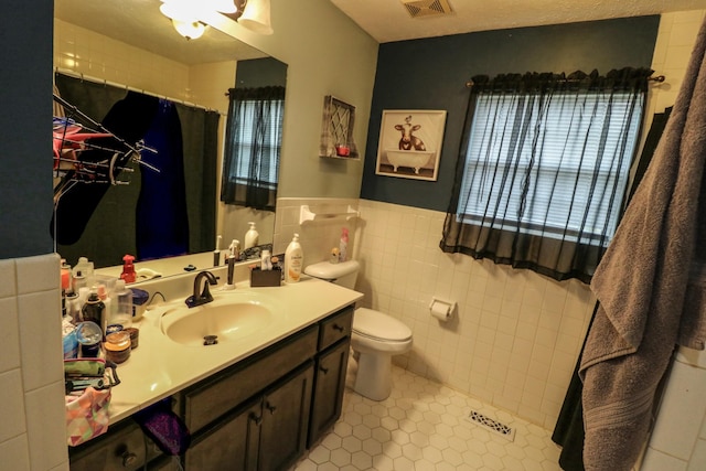 bathroom with tile walls, tile patterned flooring, vanity, toilet, and a shower with curtain