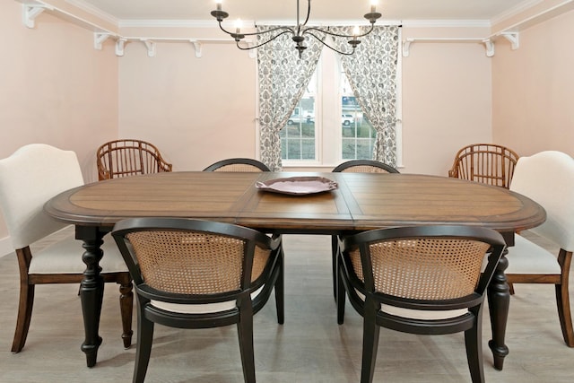 dining area with crown molding and a chandelier