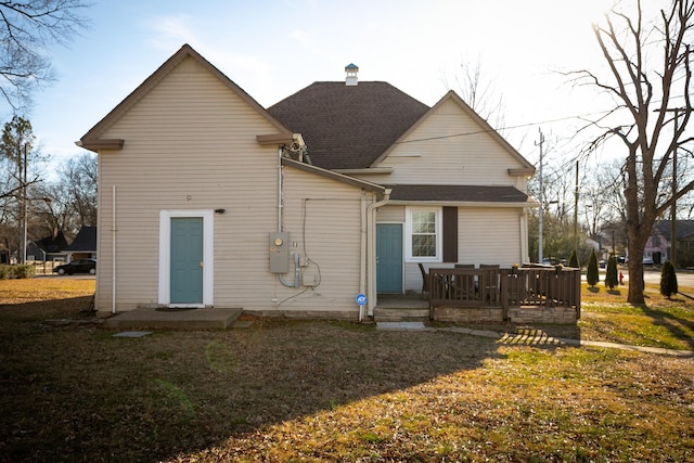 rear view of property featuring a yard and a deck