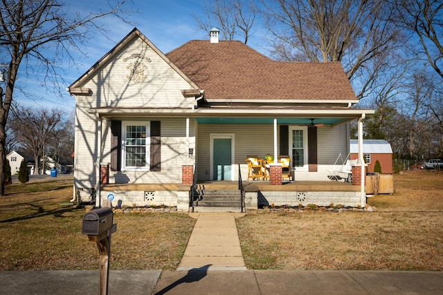 bungalow featuring covered porch and a front lawn