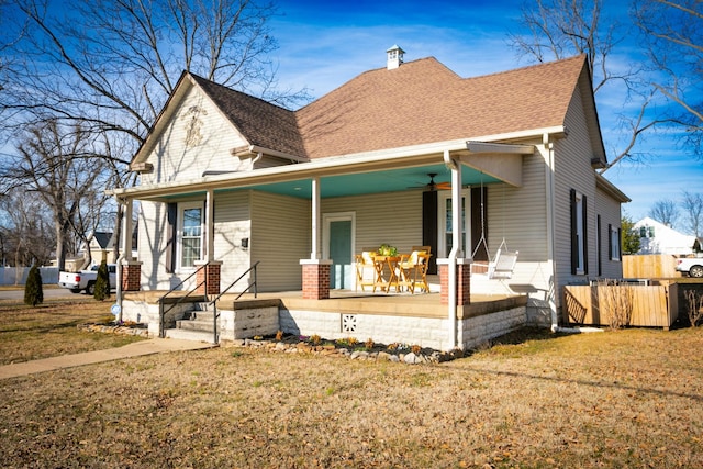 view of front facade featuring a front yard, ceiling fan, and covered porch