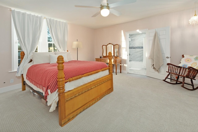 bedroom featuring light carpet, ceiling fan, and ensuite bath