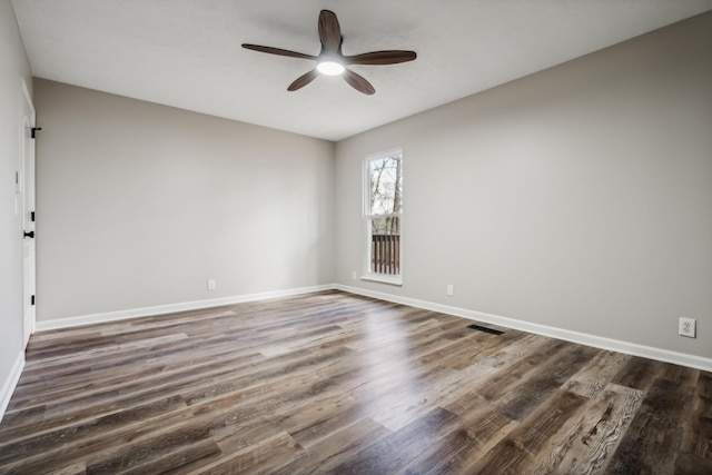 empty room featuring dark wood-type flooring and ceiling fan