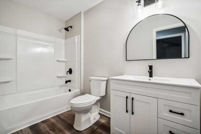 full bathroom with hardwood / wood-style flooring, washtub / shower combination, vanity, and toilet