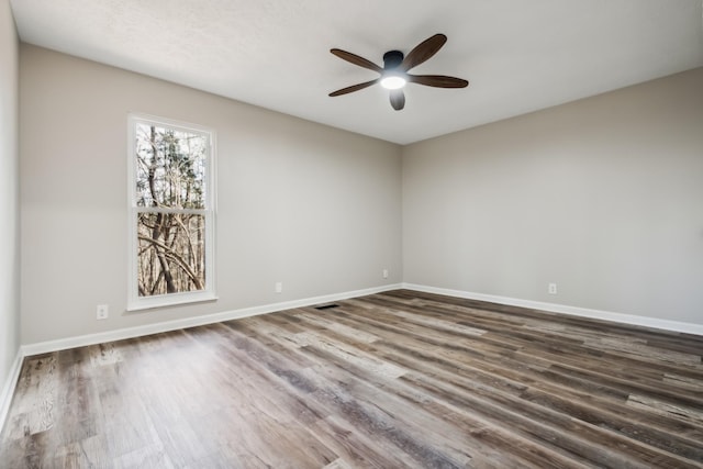 empty room with dark hardwood / wood-style flooring and ceiling fan