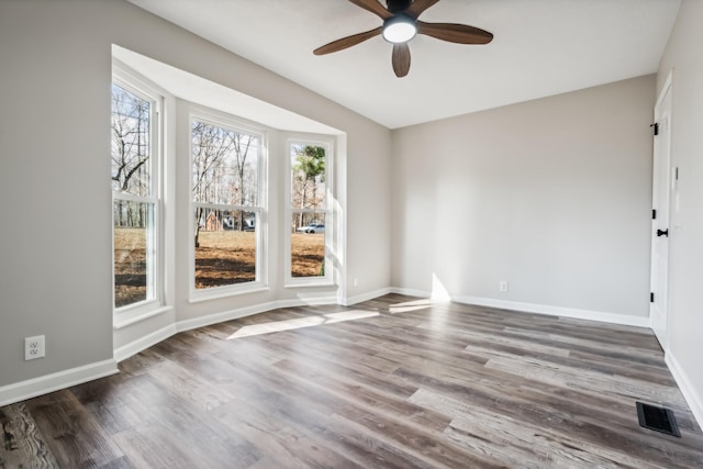 spare room with dark hardwood / wood-style floors and ceiling fan