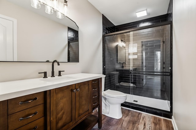 bathroom with vanity, hardwood / wood-style floors, an enclosed shower, and toilet