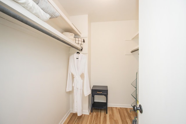 walk in closet with light wood-style floors