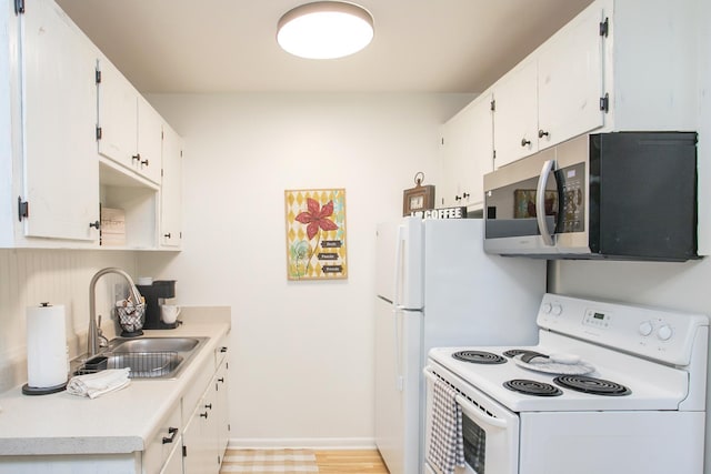 kitchen with white electric stove, a sink, white cabinetry, light countertops, and stainless steel microwave