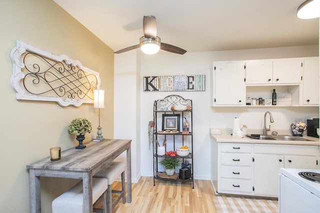 kitchen featuring white cabinetry, sink, ceiling fan, and light hardwood / wood-style flooring