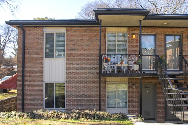 view of front of house featuring stairs and brick siding