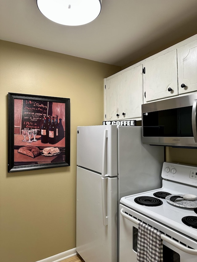 kitchen with white cabinetry, stainless steel microwave, and electric stove