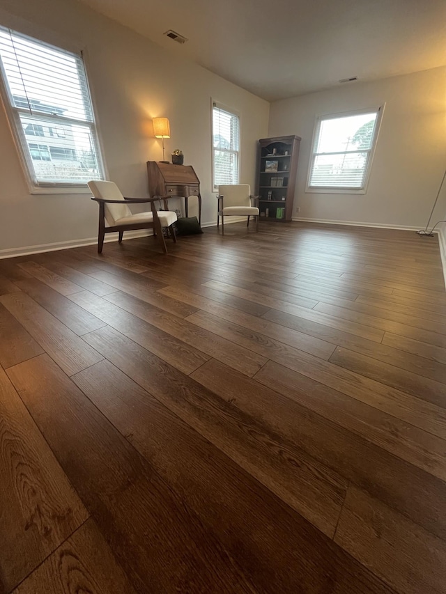 unfurnished room with a healthy amount of sunlight and dark wood-type flooring