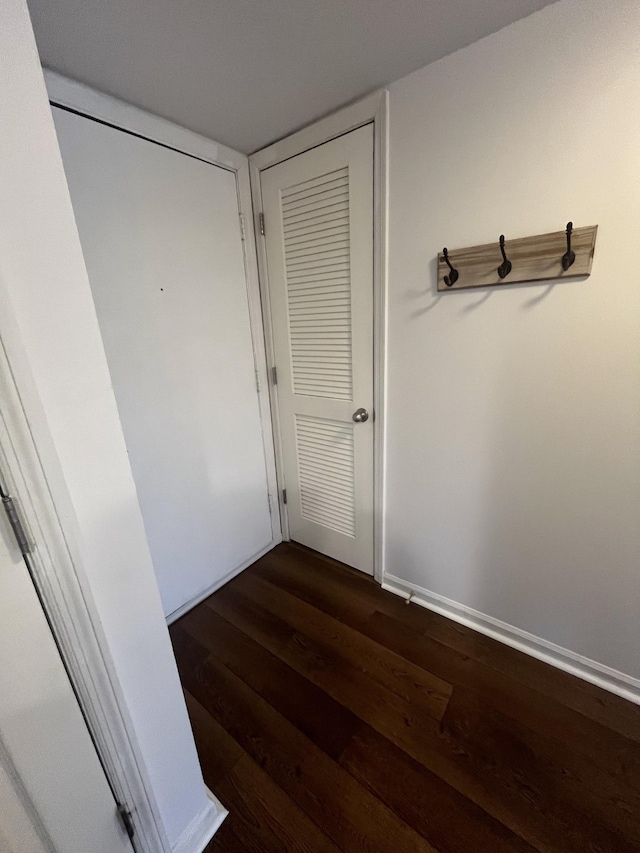 hallway with dark hardwood / wood-style flooring