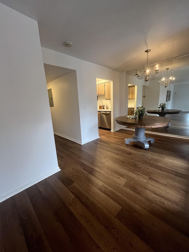 unfurnished dining area with sink, a chandelier, and dark hardwood / wood-style flooring