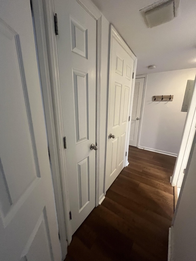 corridor with dark hardwood / wood-style flooring