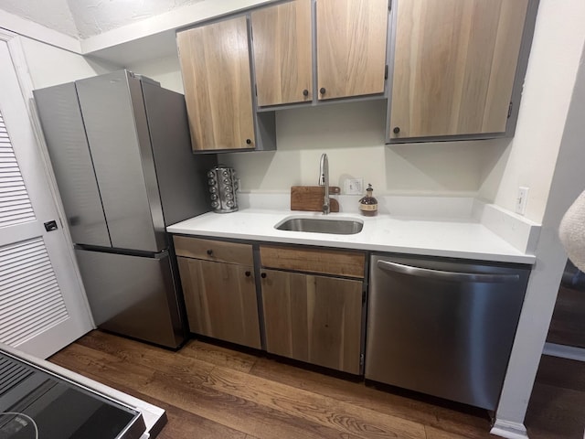 kitchen featuring appliances with stainless steel finishes, sink, and dark hardwood / wood-style floors