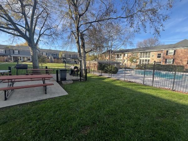 view of community featuring a pool and a yard