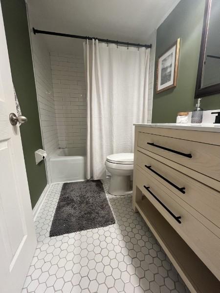 full bathroom featuring vanity, tile patterned floors, toilet, and shower / bath combo with shower curtain