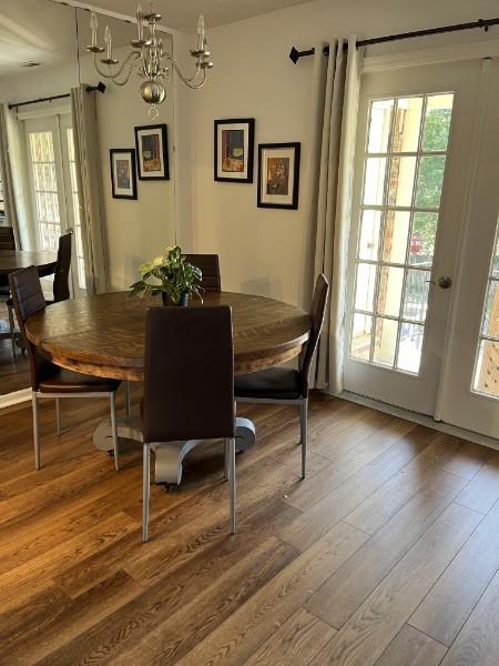 dining room featuring an inviting chandelier, wood-type flooring, and french doors