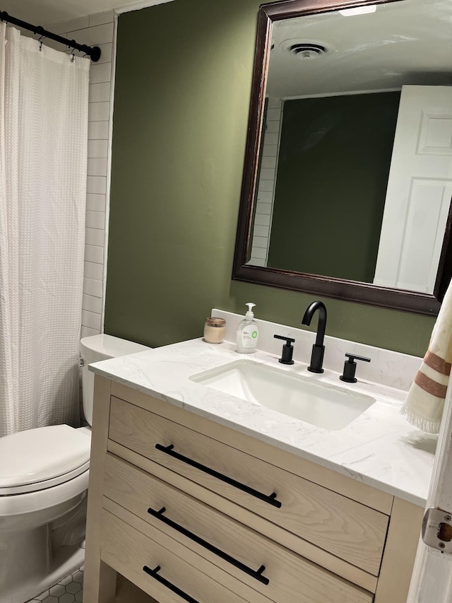 bathroom with vanity, a shower with shower curtain, and toilet