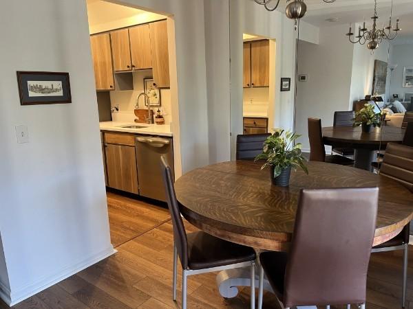 dining space with sink, a notable chandelier, and hardwood / wood-style floors