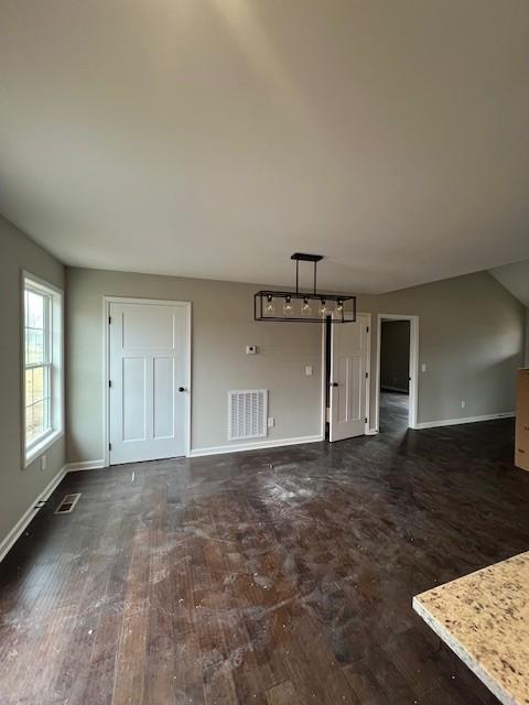 unfurnished living room with dark wood-type flooring