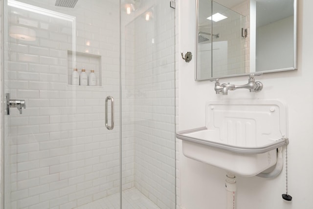 bathroom with sink and a shower with shower door