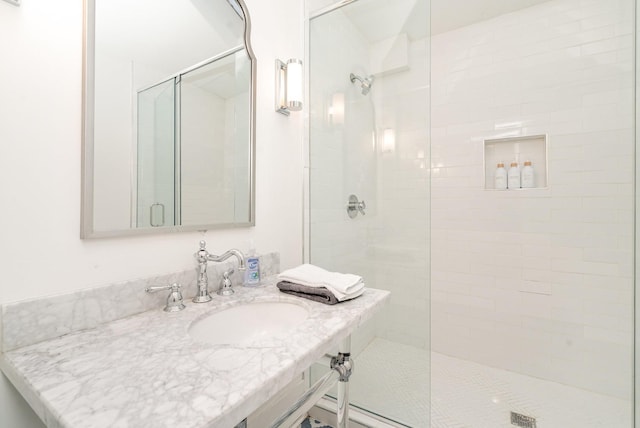 bathroom with an enclosed shower and sink