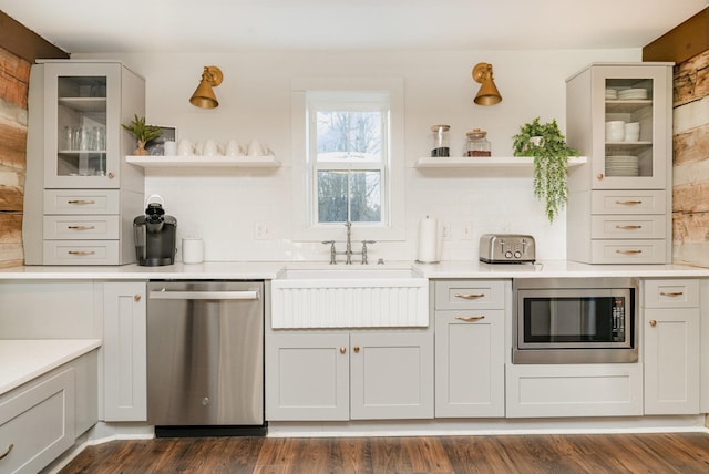 kitchen with white cabinetry, sink, backsplash, dark hardwood / wood-style flooring, and stainless steel appliances