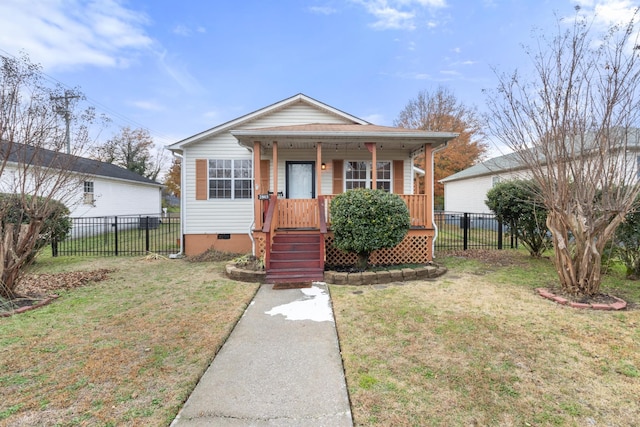 bungalow-style house with crawl space, covered porch, fence, and a front lawn