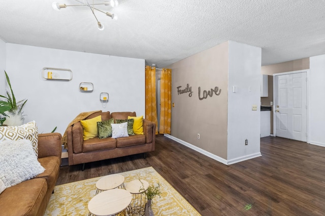 living room featuring a textured ceiling, baseboards, and wood finished floors