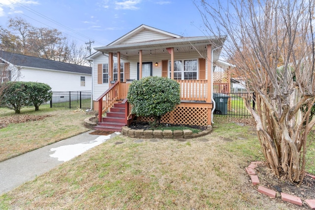 view of front of property with covered porch, a front yard, and fence