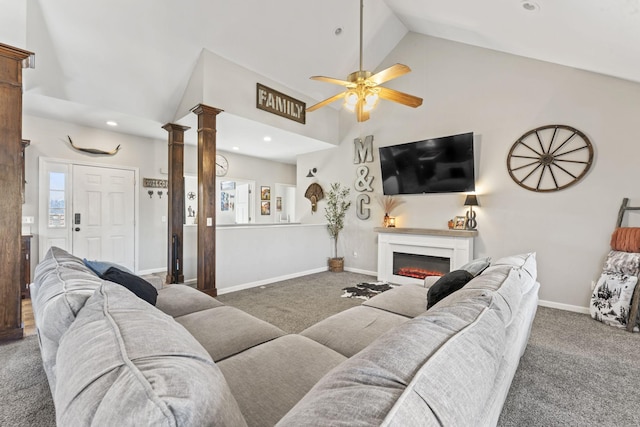 carpeted living room with ceiling fan, high vaulted ceiling, and ornate columns