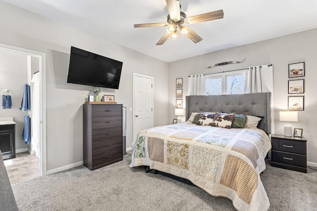 carpeted bedroom with ceiling fan and ensuite bath