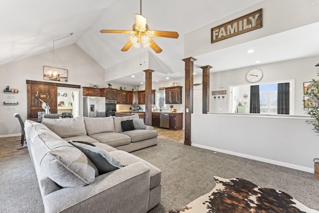 living room featuring ornate columns, ceiling fan, carpet flooring, and high vaulted ceiling