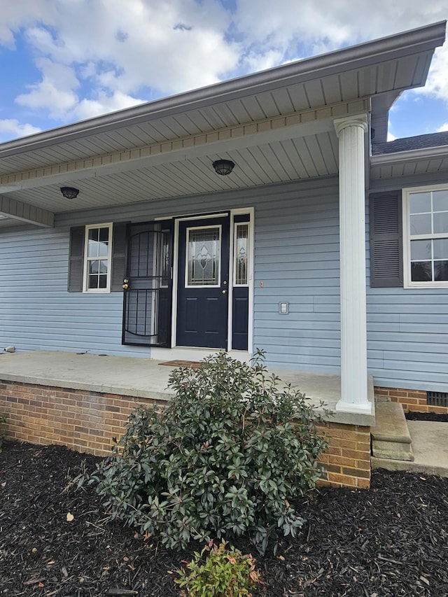 view of exterior entry with covered porch