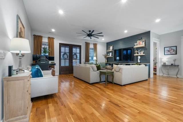 living room featuring french doors, ceiling fan, and light wood-type flooring