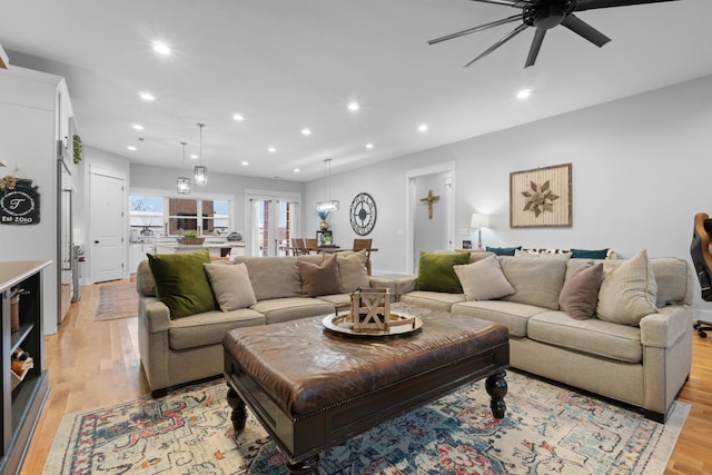 living room featuring ceiling fan and light hardwood / wood-style flooring