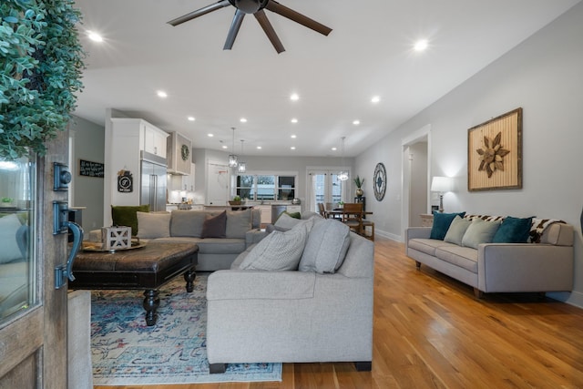 living room with ceiling fan and light hardwood / wood-style floors