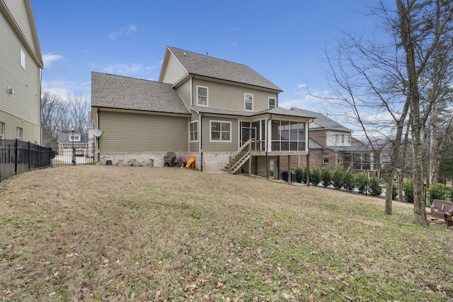 rear view of house featuring a yard and a sunroom