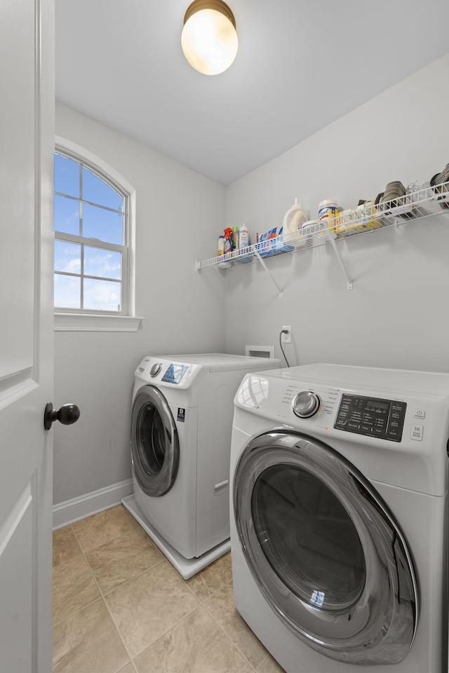 washroom featuring washer and clothes dryer and light tile patterned floors