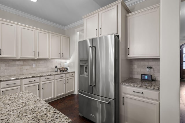 kitchen with dark wood-type flooring, crown molding, light stone counters, high quality fridge, and white cabinets