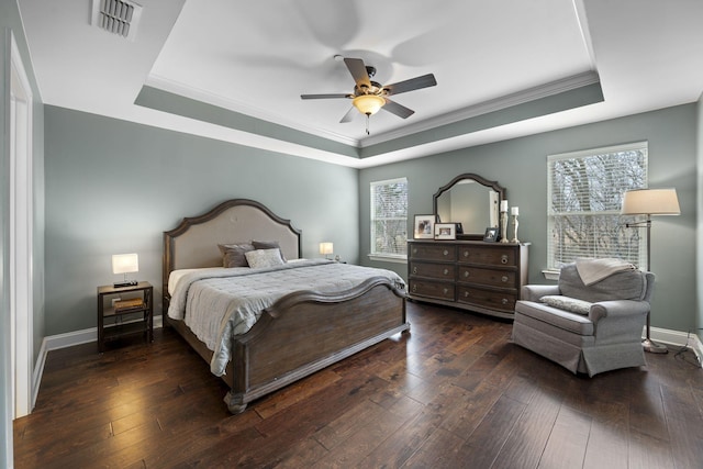 bedroom with ceiling fan, ornamental molding, dark hardwood / wood-style flooring, and a raised ceiling