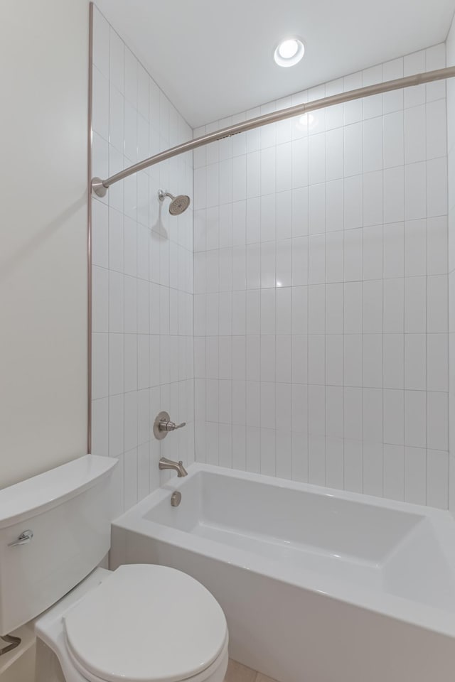 bathroom featuring tiled shower / bath and toilet