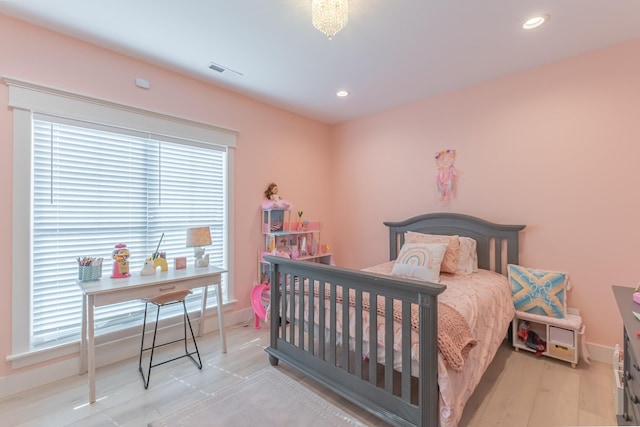 bedroom featuring multiple windows and light hardwood / wood-style flooring