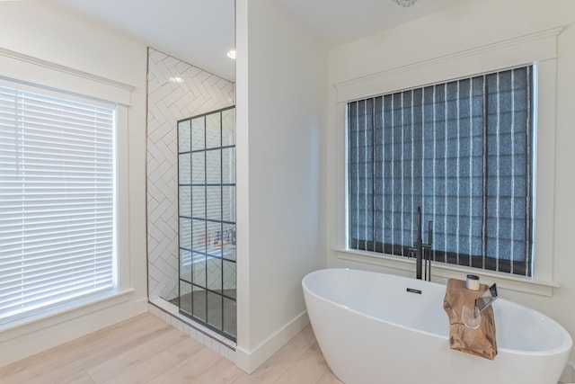 bathroom featuring hardwood / wood-style floors and plus walk in shower