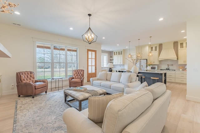 living room featuring a notable chandelier and light wood-type flooring