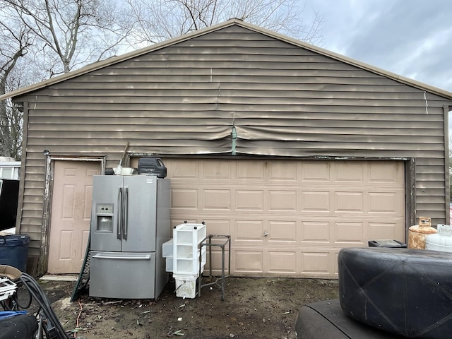 garage with stainless steel fridge with ice dispenser