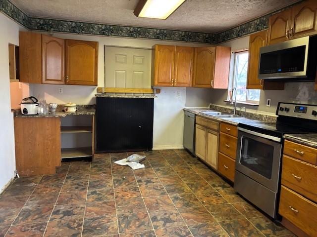 kitchen featuring appliances with stainless steel finishes, sink, and a textured ceiling